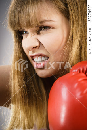 Angry woman wearing boxing gloves 125279605