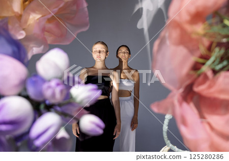 women wearing tops while posing together on floral background 125280286