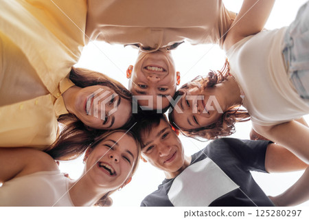 Funny smiling teenagers standing and looking down at camera Funny smiling teenagers standing and looking down at camera 125280297