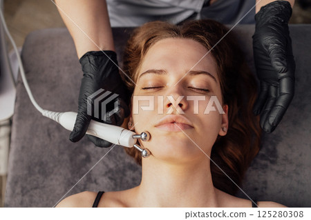 Microcurrent medicine treatment. Portrait of beautiful woman. Microcurrent medicine treatment. Portrait of beautiful woman. 125280308
