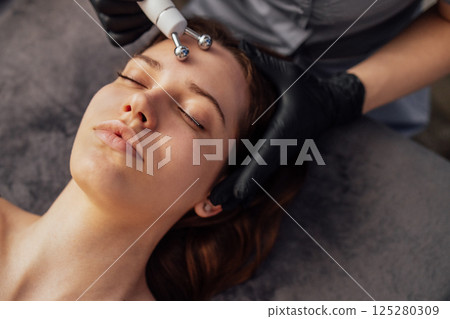 Microcurrent medicine treatment. Portrait of beautiful woman. 125280309