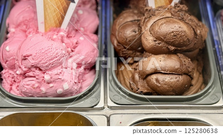 An inviting and delightful selection of colorful and various ice cream flavors is beautifully served in a display case. Close-up. An inviting and delightful selection of colorful and various ice cream flavors is beautifully served in a display case. Close-up. 125280638