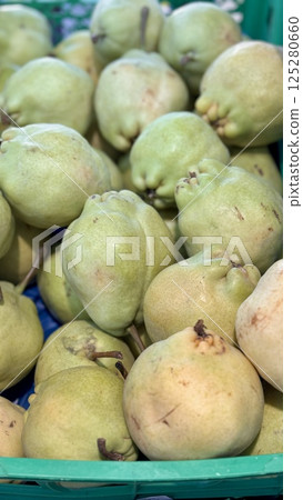 A bountiful collection of fresh, ripe green pears beautifully nestled in a charming basket, perfect for healthy eating. Close-up. 125280660