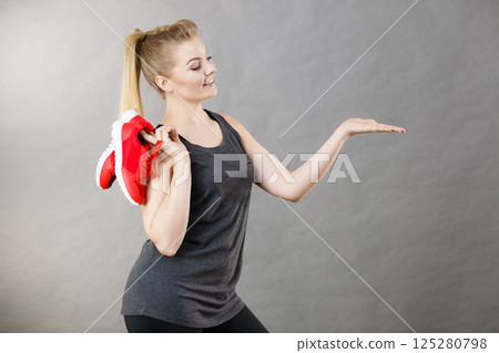 Happy woman presenting sportswear trainers shoes Happy woman presenting sportswear trainers shoes 125280798