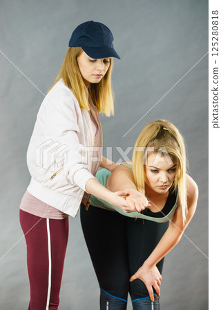 Woman in sportswear doing workout with trainer 125280818