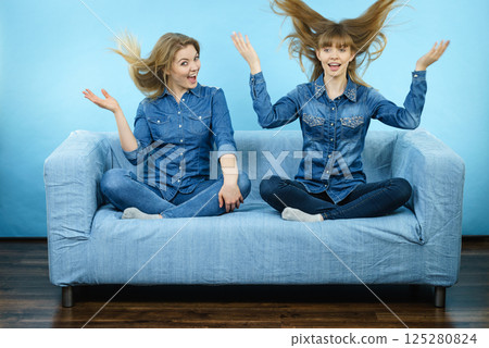 Two happy shocked women with windblown hair Two happy shocked women with windblown hair 125280824