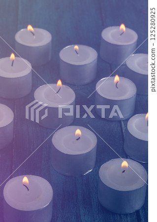 Tea light candles on a dark background, many lights in the dark 125280925