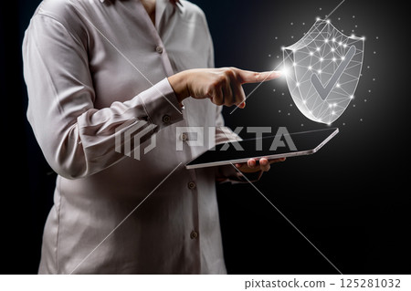 Businessperson holding tablet while touching wireframe protection shield icon. Technology innovation on a virtual screen. Concept of Business Financial Warranty and Guarantee Insurance 125281032