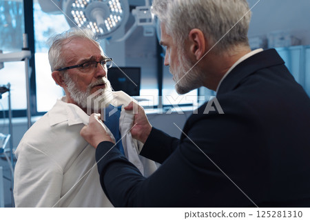 Aggressive man have conflict with doctor, holding him by coat. 125281310