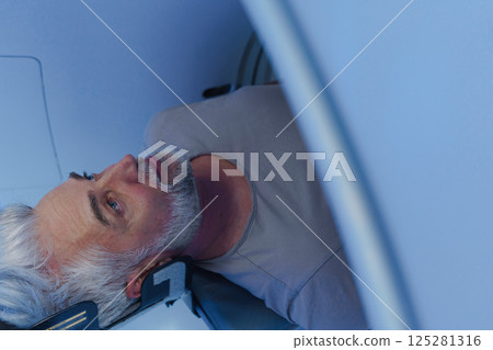 Male patient undergoing CT scan examination in hospital. 125281316