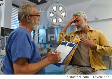 Patient sitting on examination table, describing symptoms to doctor. Patient sitting on examination table, describing symptoms to doctor. 125281353