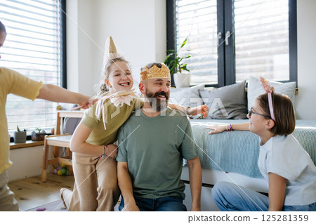 Portrait of father with three daughters at home. 125281359