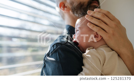 Father comforting his crying baby son. Father comforting his crying baby son. 125281370