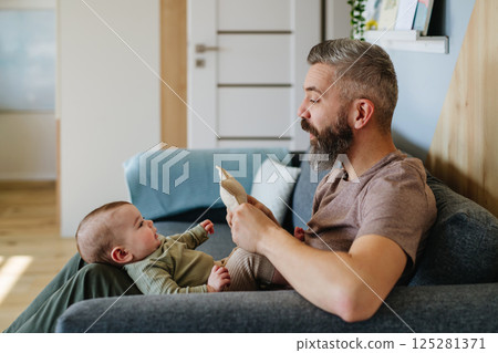 Father holding baby boy on his lap. Father holding baby boy on his lap. 125281371