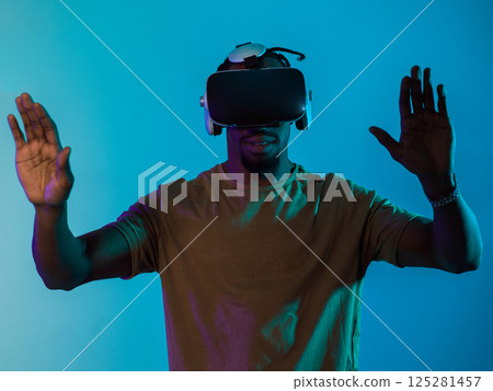 Immersed in a digital realm, an African American man navigates the virtual landscape with a VR goggles, using tactile gestures to interact with virtual objects, showcasing a harmonious blend of Immersed in a digital realm, an African American man navigates the virtual landscape with a VR goggles, using tactile gestures to interact with virtual objects, showcasing a harmonious blend of 125281457
