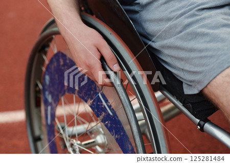 Close up photo of a person with disability in a wheelchair training tirelessly on the track in preparation for the Paralympic Games 125281484