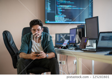 A programmer diligently testing smartphone applications  125281601