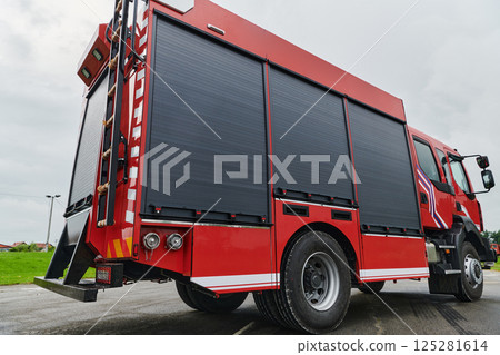 In this captivating scene, a state-of-the-art firetruck, equipped with advanced rescue technology, stands ready with its skilled firefighting team, prepared to intervene and respond rapidly to 125281614