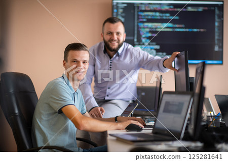 Programmers engrossed in deep collaboration, diligently working together to solve complex problems Programmers engrossed in deep collaboration, diligently working together to solve complex problems 125281641