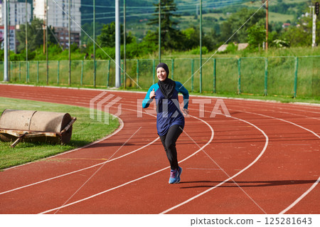 A muslim woman in a burqa sports muslim clothes running on a marathon course and preparing for upcoming competitions 125281643