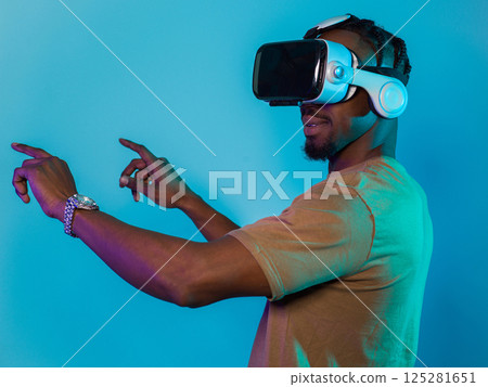 Immersed in a digital realm, an African American man navigates the virtual landscape with a VR goggles, using tactile gestures to interact with virtual objects, showcasing a harmonious blend of Immersed in a digital realm, an African American man navigates the virtual landscape with a VR goggles, using tactile gestures to interact with virtual objects, showcasing a harmonious blend of 125281651