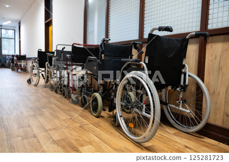 A row of wheelchairs neatly lined up in a hospital corridor, ready for patients in need of mobility assistance 125281723