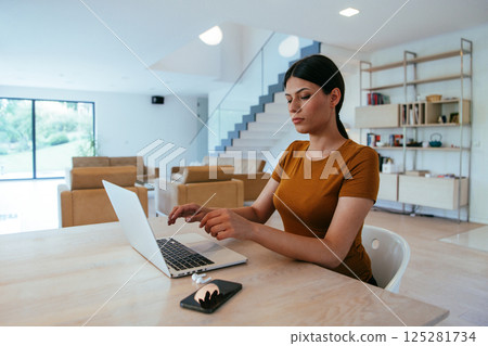 Woman sitting in living room using laptop looking at cam talk by video call with business friend relatives, head shot. Job interview answering questions Woman sitting in living room using laptop looking at cam talk by video call with business friend relatives, head shot. Job interview answering questions 125281734
