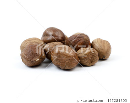 Brown hazelnuts arranged on a clean white surface 125281803