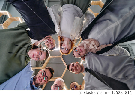 In a modern office, a group of young business professionals is captured in a warm and embracing hug, reflecting the spirit of unity, collaboration, and shared success in their dynamic workplace. In a modern office, a group of young business professionals is captured in a warm and embracing hug, reflecting the spirit of unity, collaboration, and shared success in their dynamic workplace. 125281814