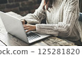 A woman working on a computer at a table 125281820