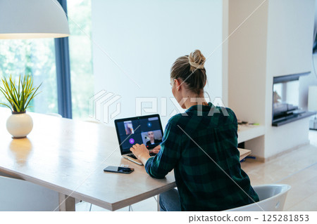 Woman sitting in living room using laptop looking at cam talk by video call with business friend relatives, head shot. Job interview answering questions Woman sitting in living room using laptop looking at cam talk by video call with business friend relatives, head shot. Job interview answering questions 125281853