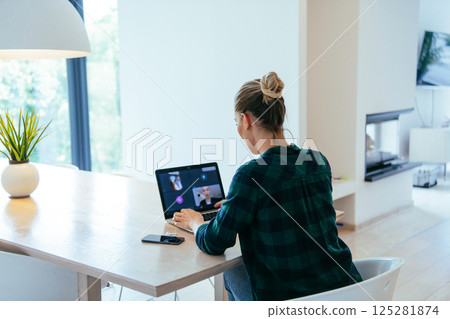 Woman sitting in living room using laptop looking at cam talk by video call with business friend relatives, head shot. Job interview answering questions 125281874