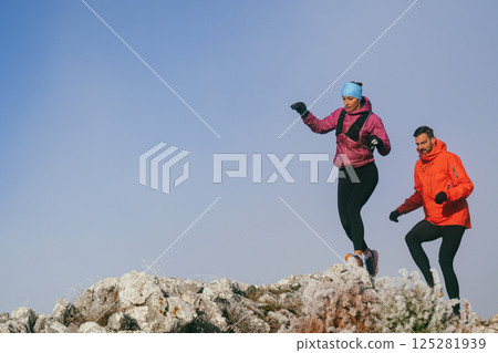 Trail running couple man and woman running on a mountain path 125281939