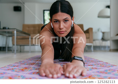 Young Beautiful Female Exercising, Stretching and Practising Yoga with Trainer via Video Call Conference in Bright Sunny House. Healthy Lifestyle, Wellbeing and Mindfulness Concept 125282113