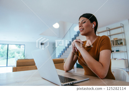 Woman sitting in living room using laptop looking at cam talk by video call with business friend relatives, head shot. Job interview answering questions 125282114