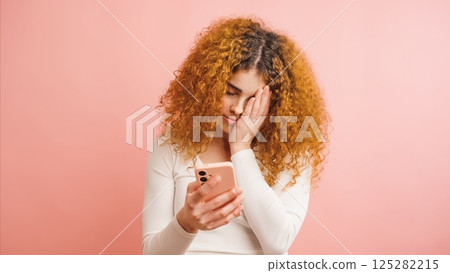 Young woman feeling tired while reading bad news on mobile phone Young woman feeling tired while reading bad news on mobile phone 125282215