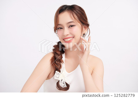 A beautiful young Asian woman with clean, fresh skin against a white background. Skincare, facial treatment, cosmetology, beauty, and spa. An elegant portrait of an Asian woman. A beautiful young Asian woman with clean, fresh skin against a white background. Skincare, facial treatment, cosmetology, beauty, and spa. An elegant portrait of an Asian woman. 125282779