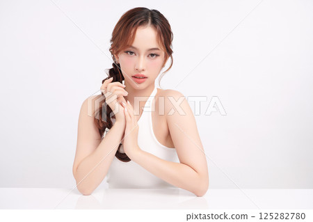 A beautiful young Asian woman with clean, fresh skin against a white background. Skincare, facial treatment, cosmetology, beauty, and spa. An elegant portrait of an Asian woman. 125282780