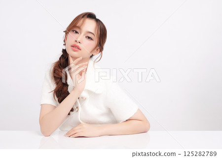 A beautiful young Asian woman with clean, fresh skin against a white background. Skincare, facial treatment, cosmetology, beauty, and spa. An elegant portrait of an Asian woman. A beautiful young Asian woman with clean, fresh skin against a white background. Skincare, facial treatment, cosmetology, beauty, and spa. An elegant portrait of an Asian woman. 125282789