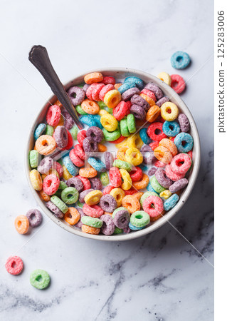 Colorful fruit cereal in bowl on white marble background. 125283006