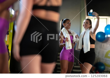 Two fitness women posing for a photoshoot after an intense workout, capturing their strength, determination, and fitness journey. 125283068