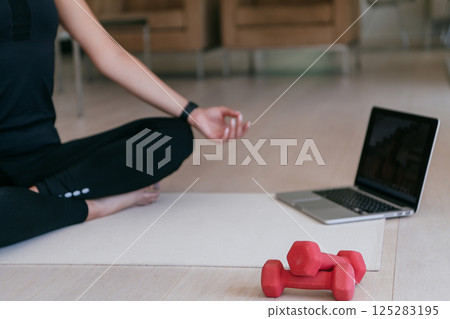 Young Beautiful Female Exercising, Stretching and Practising Yoga with Trainer via Video Call Conference in Bright Sunny House. Healthy Lifestyle, Wellbeing and Mindfulness Concept. Young Beautiful Female Exercising, Stretching and Practising Yoga with Trainer via Video Call Conference in Bright Sunny House. Healthy Lifestyle, Wellbeing and Mindfulness Concept. 125283195