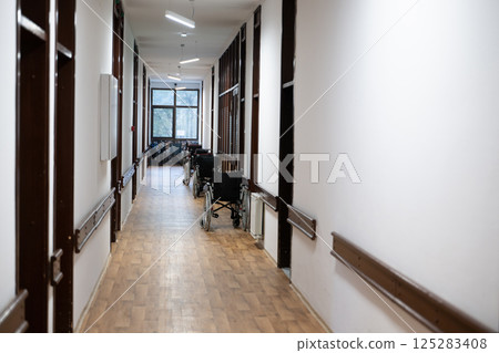 A row of wheelchairs neatly lined up in a hospital corridor, ready for patients in need of mobility assistance A row of wheelchairs neatly lined up in a hospital corridor, ready for patients in need of mobility assistance 125283408