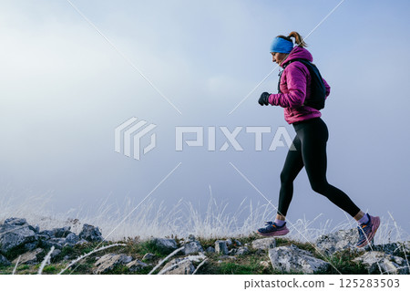 Trail Runner in Misty Mountain Landscape Trail Runner in Misty Mountain Landscape 125283503