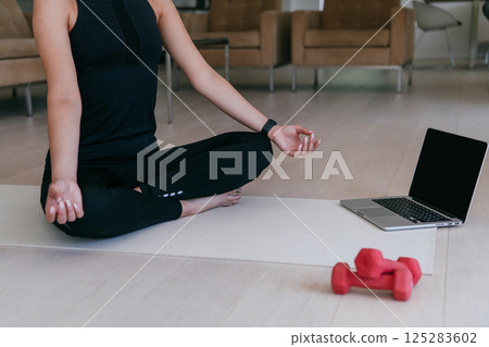 Young Beautiful Female Exercising, Stretching and Practising Yoga with Trainer via Video Call Conference in Bright Sunny House. Healthy Lifestyle, Wellbeing and Mindfulness Concept. 125283602