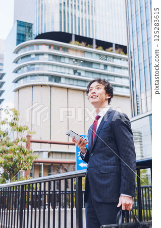 一名男子在辦公區使用智慧型手機 一名男子在辦公區使用智慧型手機 125283615