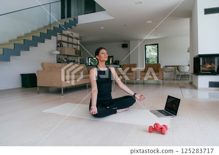 Young Beautiful Female Exercising, Stretching and Practising Yoga with Trainer via Video Call Conference in Bright Sunny House. Healthy Lifestyle, Wellbeing and Mindfulness Concept. 125283717