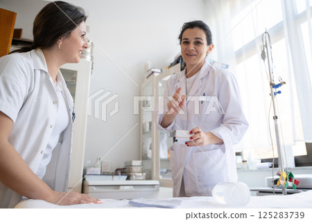 Two nurses in a hospital laboratory are carefully inspecting and preparing medications for patients and hospital use. Two nurses in a hospital laboratory are carefully inspecting and preparing medications for patients and hospital use. 125283739