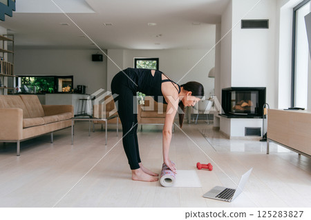 Young Beautiful Female Exercising, Stretching and Practising Yoga with Trainer via Video Call Conference in Bright Sunny House. Healthy Lifestyle, Wellbeing and Mindfulness Concept. 125283827