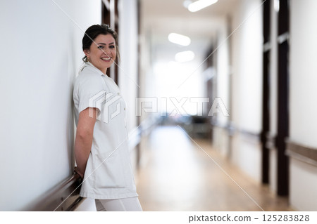 A tired nurse takes a quiet moment to rest in the hospital hallway, reflecting on a long and demanding shift. 125283828